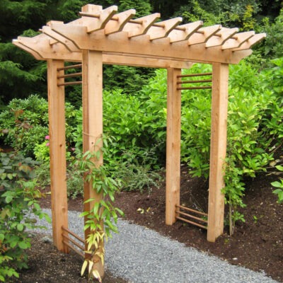 All wood arbor constructed over a rock walking path in a garden in Seattle, Washington.