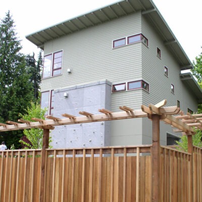 Custom and contemporary fence created for a residence near Seattle, Washington boasts a pagoda type styling on the top of the railing.