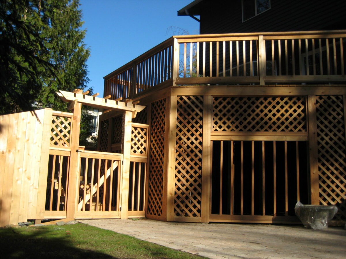 Large two story outdoor structure with lattice woodwork, deck and arbor at residence in Seattle, Washington.