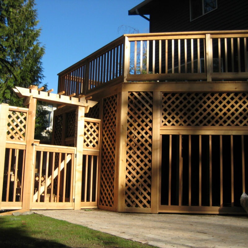 Large two story outdoor structure with lattice woodwork, deck and arbor at residence in Seattle, Washington.