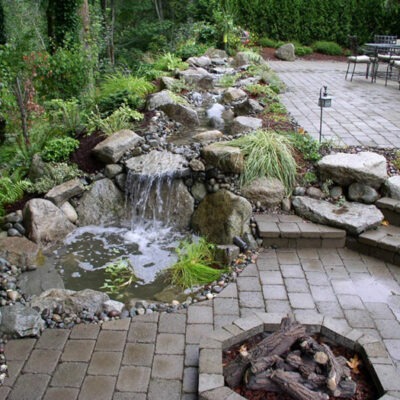 Enjoy a custom rock patio and rock fire pit that can burn gas or natural wood burning to warm the Pacific Northwest nights.