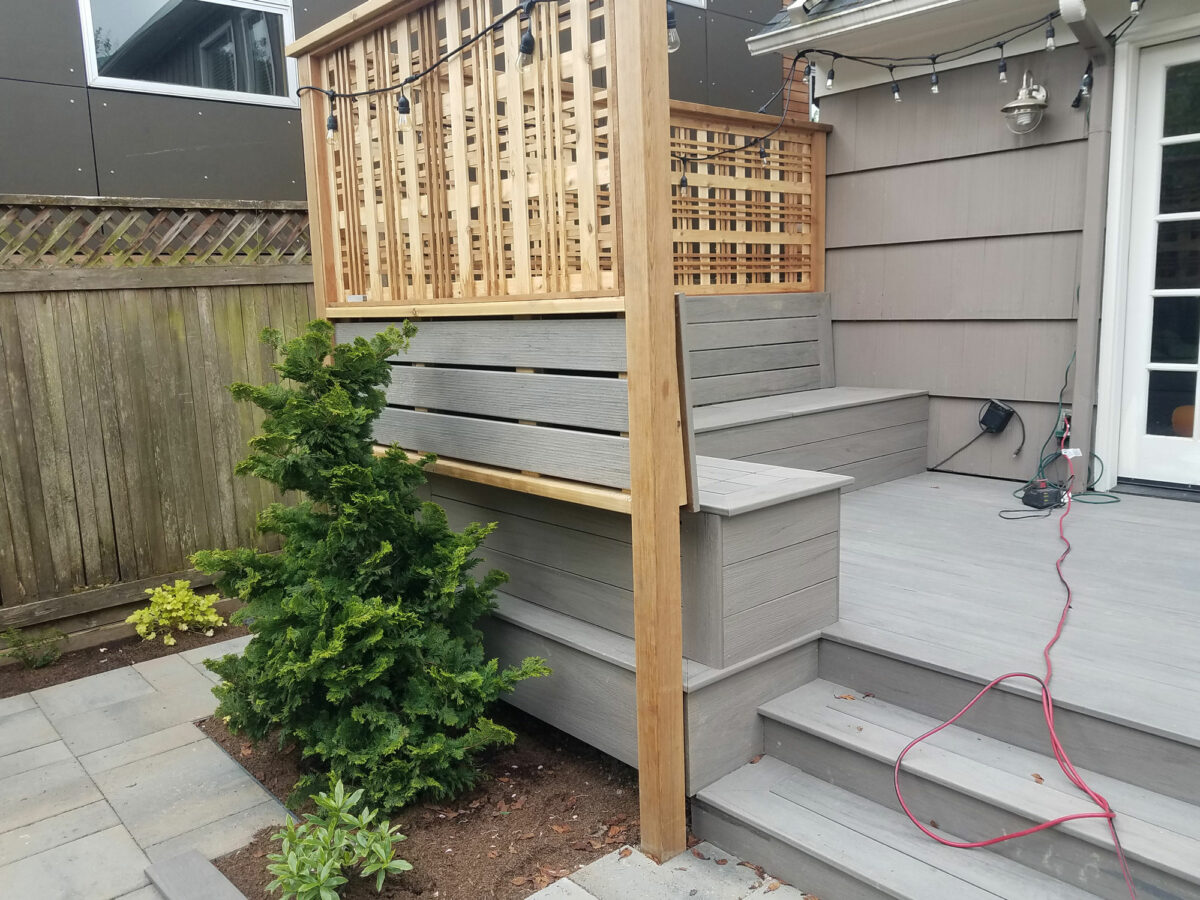 A custom deck is lined with a decorative privacy fence in residential backyard in Seattle.