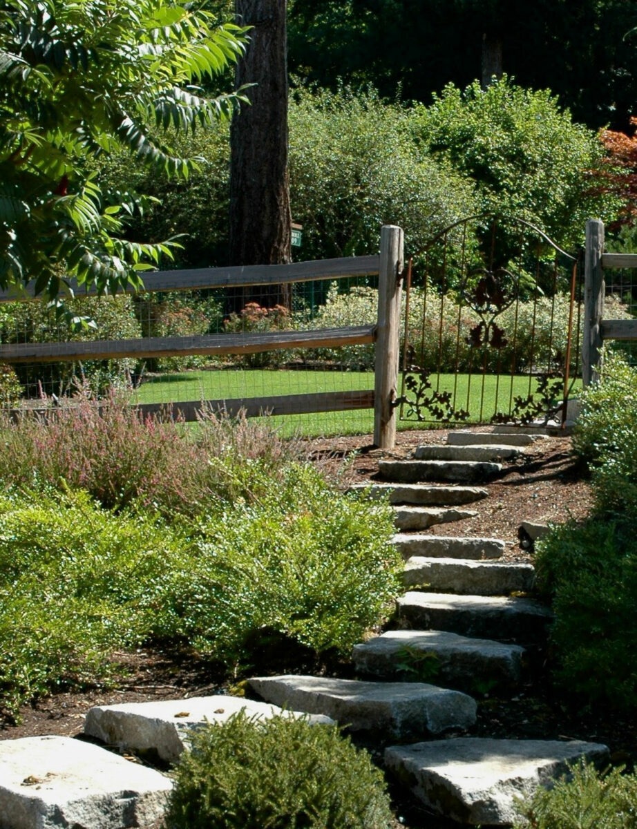 Large stone and concrete steps create a walking path through garden gate in Seattle, Washington.